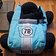 Kaya joined the competition — help win amazing prizes! cat, black_cat, plush_car_bed, soft_toy, indoor, wooden_floor, pet_bed, cute, animal, feline, cozy, stuffed_toy, car_shaped_bed, pet, relaxed, toy_car, number_78, flooring, home, curious