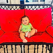 Avyan joined the competition — help win amazing prizes! baby, child, smiling, green_clothing, red_cushion, swing_chair, indoor, happy, feet, cushion, furniture, playful, person, infant, relaxing, seat, home, cute, smile, comfort