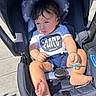 baby, bare_feet, child, clothing, eyes, face, grandchild, hair, headrest, infant, outdoor, pacifier, pavement, portrait, shirt, shorts, sitting, stars, stroller, sunlight