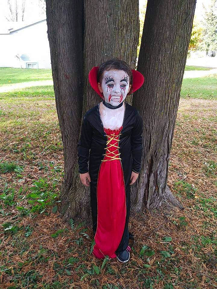 Isabella is registered to the contest to win money with this photo: carmine, child, costume, deciduous, eye, fur, grass, head, lawn_ornament, leaf, people_in_nature, person, plant, plant_stem, scarecrow, tree, trunk, twig, wood, woodland