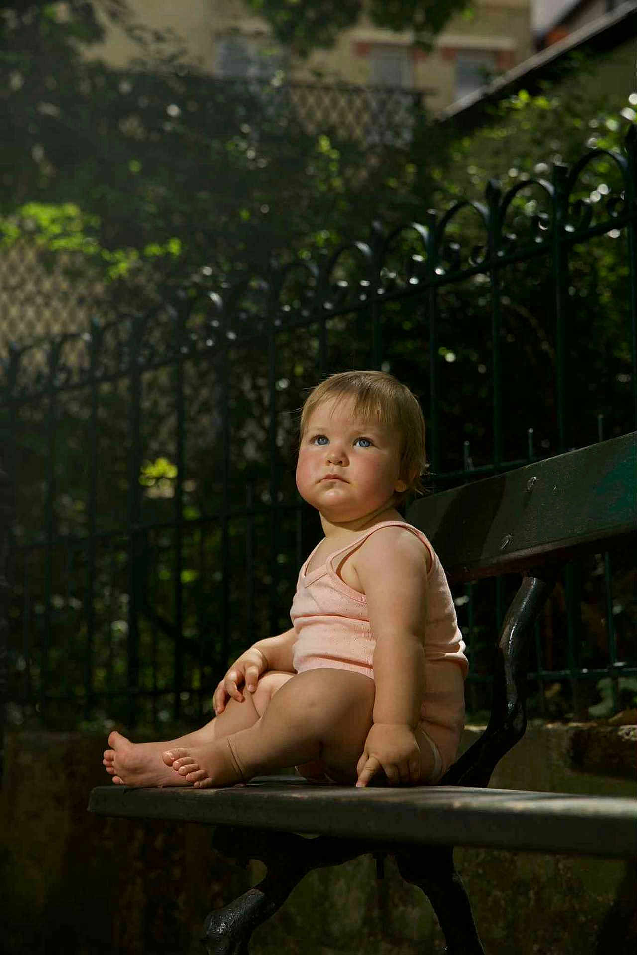 Gabrielle a rejoint le concours — aidez-le/la à gagner de superbes lots ! toddler, child, bench, outdoor, park, fence, greenery, daylight, portrait, sitting, curious, cute, summer, baby, skin, clothing, feet, expression, face, nature