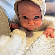 Oliver joined the competition — help win amazing prizes! baby, child, face, blue_eyes, knitted_hat, blanket, closeup, portrait, infant, curious, soft_texture, couch, indoors, cozy, cute, young_child, hand, skin, expression, warm_lighting