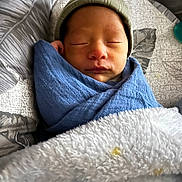Magnum joined the competition — help win amazing prizes! newborn, baby, sleeping, blanket, beanie, cozy, pillow, soft, wrapped, infant, cute, peaceful, resting, child, portrait, indoor, closeup, face, headwear, toddler