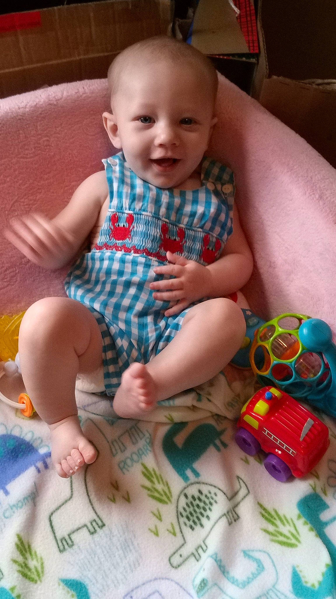 Jaxtyn is registered to the contest to win money with this photo: baby, baby_toddler_clothing, cheek, child, comfort, couch, face, facial_expression, finger, green, iris, lap, leg, pattern, person, product, skin, smile, textile, thigh