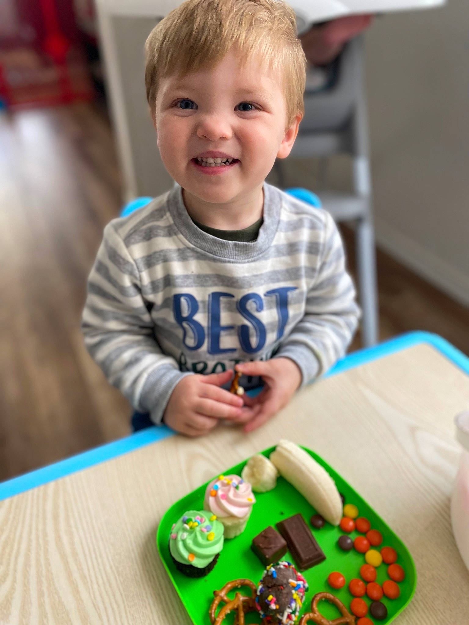 Jaxon is registered to the contest to win money with this photo: audio_equipment, baby, baby_playing_with_toys, baby_toddler_clothing, baby_toys, child, flooring, fun, green, happy, holiday, joy, person, room, sitting, smile, sweetness, t_shirt, table, toddler