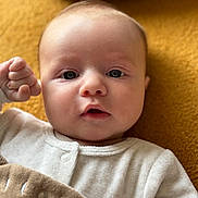 Gabriel participe au concours pour gagner de l'argent avec cette photo : baby, blanket, child, closeup, clothing, cozy, cute, expression, eyes, face, fist, hand, indoor, infant, lying_down, newborn, portrait, skin, soft_texture, warm_colors