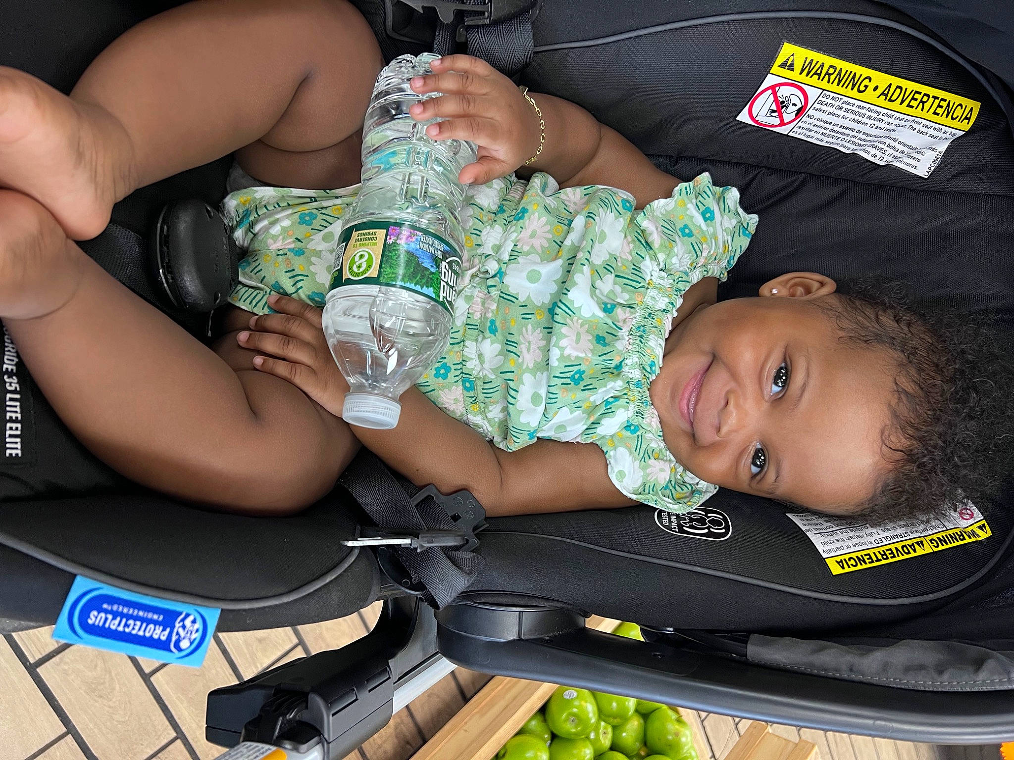 Quinn is registered to the contest to win money with this photo: baby, baby_products, baby_toddler_clothing, child, comfort, elbow, food_group, green, hand, human_leg, joy, lap, leaf_vegetable, natural_foods, person, produce, sitting, smile, thigh, toddler