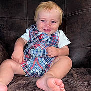 Karson is registered to the contest to win money with this photo: anchor_pattern, baby, bare_feet, blond_hair, blue_eyes, child, close_up, furniture, happy, indoors, infant, leather_couch, lifestyle, overalls, photography, plaid_clothing, portrait, sitting, smiling, white_shirt