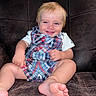 baby, child, infant, smiling, sitting, portrait, leather_couch, overalls, plaid_clothing, white_shirt, anchor_pattern, blond_hair, blue_eyes, bare_feet, indoors, furniture, happy, close_up, lifestyle, photography