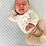 Julia a rejoint le concours — aidez-le/la à gagner de superbes lots ! baby, infant, winking, drool, blanket, soft_texture, cute, clothing, onesie, pants, lying_down, cozy, playful, hand, face, smile, skin, head, newborn, expression