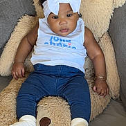 Shaïna participe au concours pour gagner de l'argent avec cette photo : baby, headband, bow, teddy_bear, cushion, white_top, blue_pants, socks, couch, indoor, child, infant, soft_toy, relaxed, portrait, curious, cute, furniture, bracelet, dark_hair