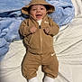baby, infant, smiling, hoodie, brown_clothing, nike_logo, white_socks, blanket, bed, striped_sheet, cute, happy, child, young, portrait, indoor, cozy, clothing, person, casual