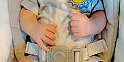 Joseph is registered to the contest to win money with this photo: baby, infant, child, seat, safety_belt, clothing, onesie, hands, feet, face, cute, comfort, indoor, soft, expression, skin, human, newborn, resting, light