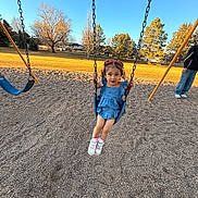 Alaura joined the competition — help win amazing prizes! child, girl, swing, playground, park, blue_sky, trees, autumn, grass, gravel, adult, casual_clothing, footwear, dress, sunlight, outdoor, smiling, play, fun, recreation
