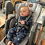 Sacha a rejoint le concours — aidez-le/la à gagner de superbes lots ! baby, baby_seat, blue_eyes, child, cushion, expression, face, floor, footrest, furniture, home, indoor, infant, modern, onesie, playpen, smile, straps, toys, wood