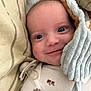 adorable, baby, blanket, child, close_up, comfort, cozy, cute, expression, face, head, indoor, infant, lying_down, pacifier, pillow, sleepwear, smile, soft_texture, young