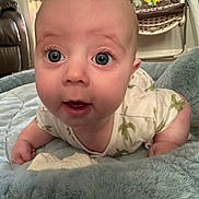 Charlie is registered to the contest to win money with this photo: baby, infant, face, eyes, mouth, skin, hand, clothing, blanket, plush, bed, indoor, toy, furniture, curious, expression, person, child, home, soft