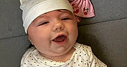 Scarlett joined the competition — help win amazing prizes! baby, infant, smiling, hat, bear_ears, polka_dot, shirt, hand, pink_bow, headband, gray_background, happy, cute, child, lying_down, closeup, apparel, cheerful, playful, adorable