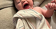 Scarlett is registered to the contest to win money with this photo: baby, bed, blanket, child, comfort, cozy, cute, expression, face, hand, happy, indoor, infant, laughing, nap, person, skin, smile, soft, towel
