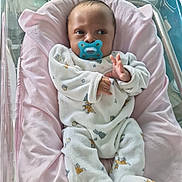 Tyron a rejoint le concours — aidez-le/la à gagner de superbes lots ! baby, infant, pacifier, crib, blanket, pink, white_clothing, onesie, face, newborn, sleeping_area, soft_toy_pattern, hospital_bassinet, hand, footed_pajamas, cute, child, person, indoor, resting