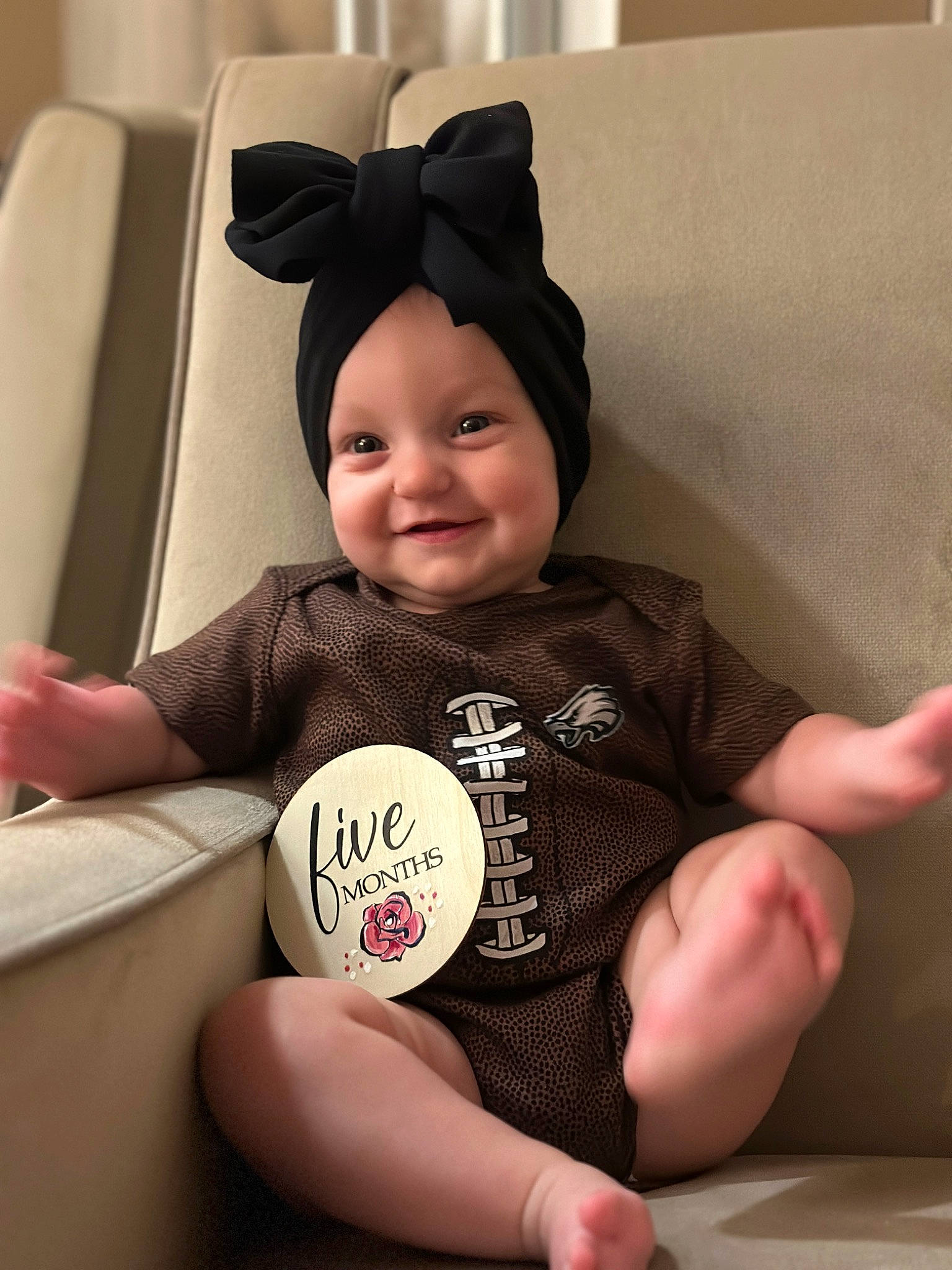 Aspyn is registered to the contest to win money with this photo: baby, baby_toddler_clothing, child, comfort, face, facial_expression, finger, fun, hairstyle, happy, head, headwear, human_leg, joy, person, room, sitting, sleeve, smile, t_shirt