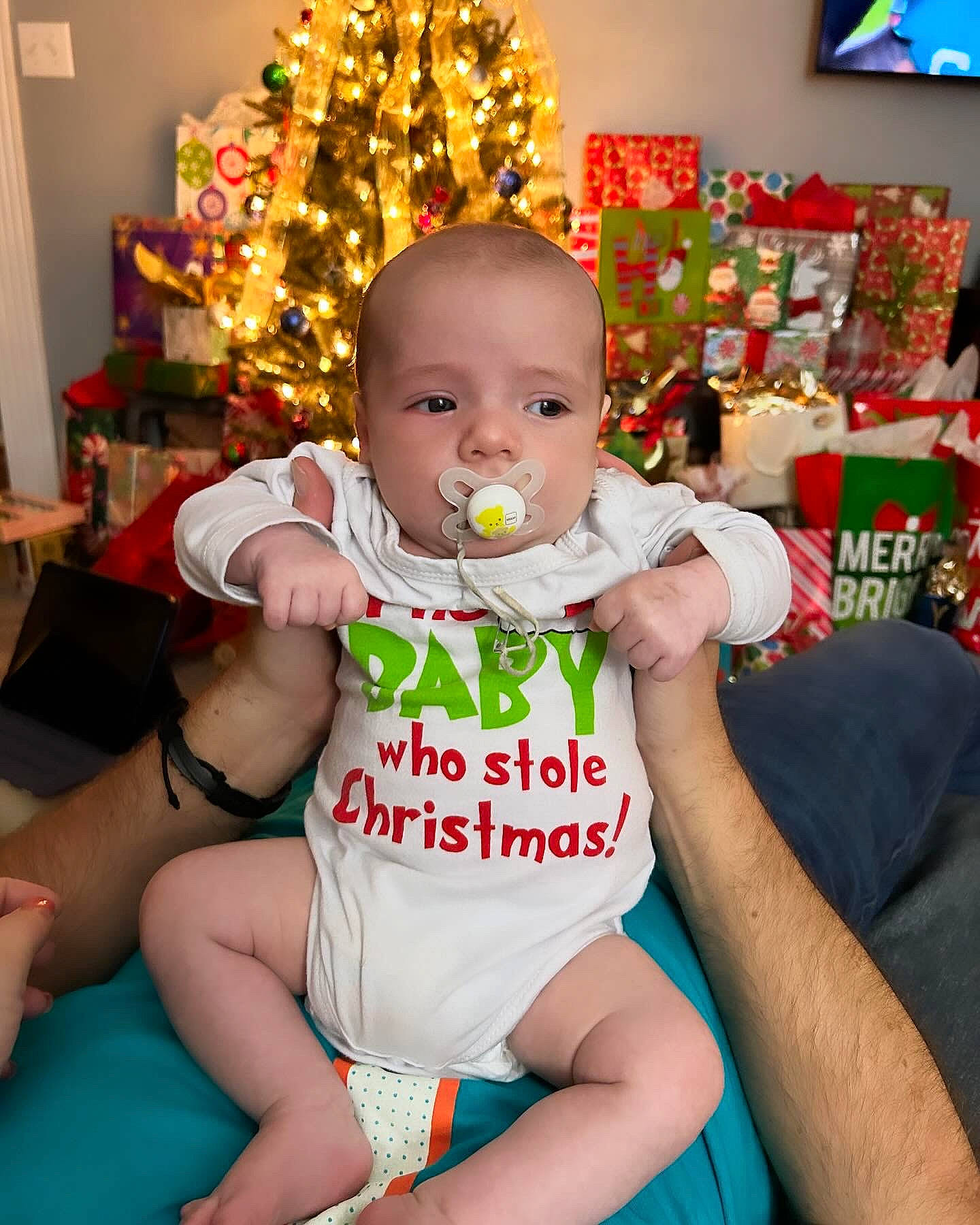 Brayden is registered to the contest to win money with this photo: baby, baby_toddler_clothing, chair, cheek, child, christmas, christmas_decoration, christmas_ornament, christmas_tree, event, fun, happy, holiday, lap, ornament, person, sitting, thigh, toddler, white