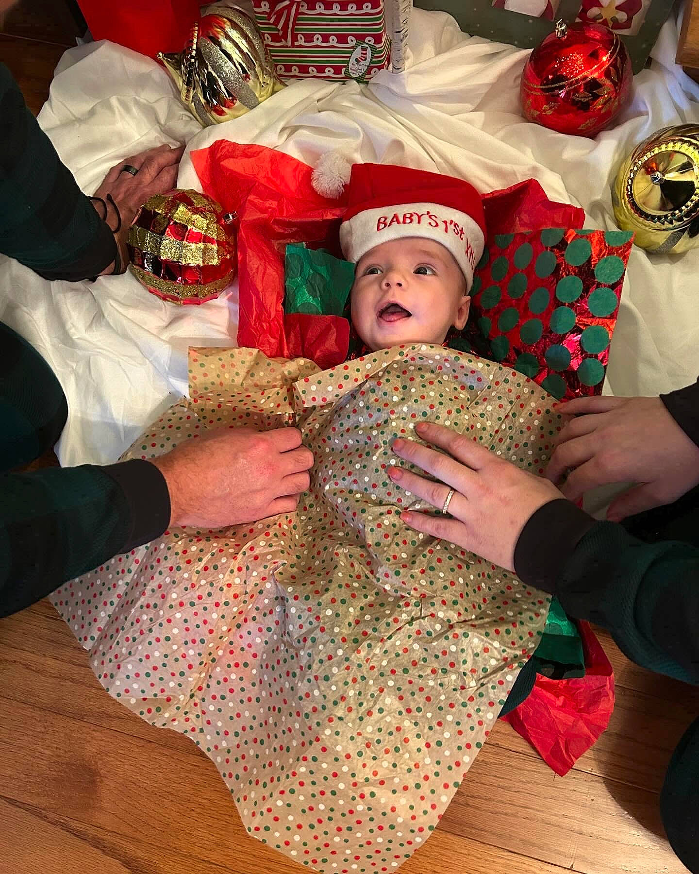 Brayden is registered to the contest to win money with this photo: baby, carmine, child, christmas, christmas_eve, christmas_ornament, comfort, event, fictional_character, flooring, fun, happy, hat, headwear, holiday, lap, pattern, person, room, santa_claus
