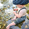 Reid is registered to the contest to win money with this photo: baby, child, water, river, rocks, hat, cap, suspenders, barefoot, outdoor, nature, curious, sitting, exploring, summer, sunlight, cute, skin, small, hands