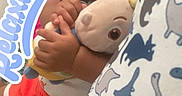 Asiyah is registered to the contest to win money with this photo: toddler, child, sleeping, plush_toy, couch, bedding, dinosaur_pattern, relaxing_text, indoors, cute, cozy, clothing, shorts, pacifier, hand, face, curly_hair, comfort, rest, soft