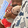toddler, child, sleeping, plush_toy, couch, bedding, dinosaur_pattern, relaxing_text, indoors, cute, cozy, clothing, shorts, pacifier, hand, face, curly_hair, comfort, rest, soft