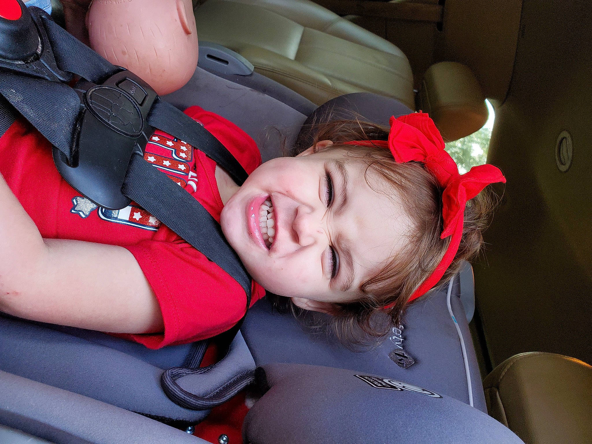 Alison is registered to the contest to win money with this photo: anger, baby_products, baseball_cap, car_seat, car_seat_cover, carmine, comfort, coquelicot, head_restraint, mammal, person, red, seat_belt, service, sorrow, throat, tongue, tooth