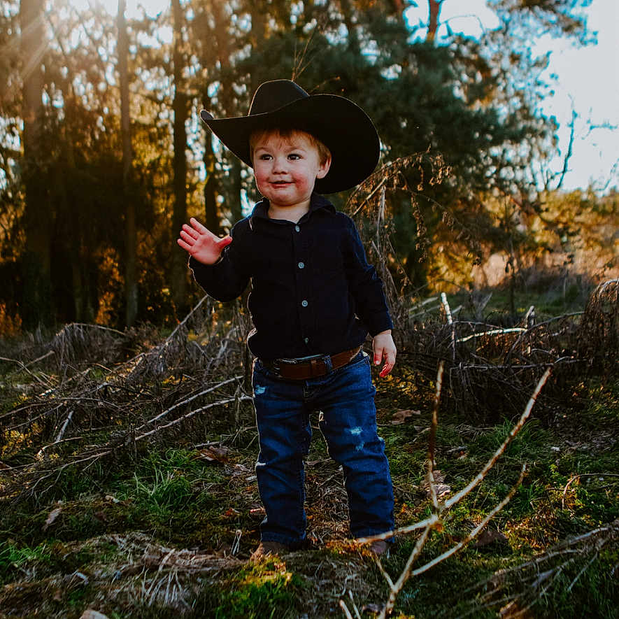Rowdy is registered to the contest to win money with this photo: accessories, belt, bodypart, boy, child, clothing, face, finger, hat, head, jeans, male, pants, person, photography, plant, portrait, sunhat, tree, vegetation