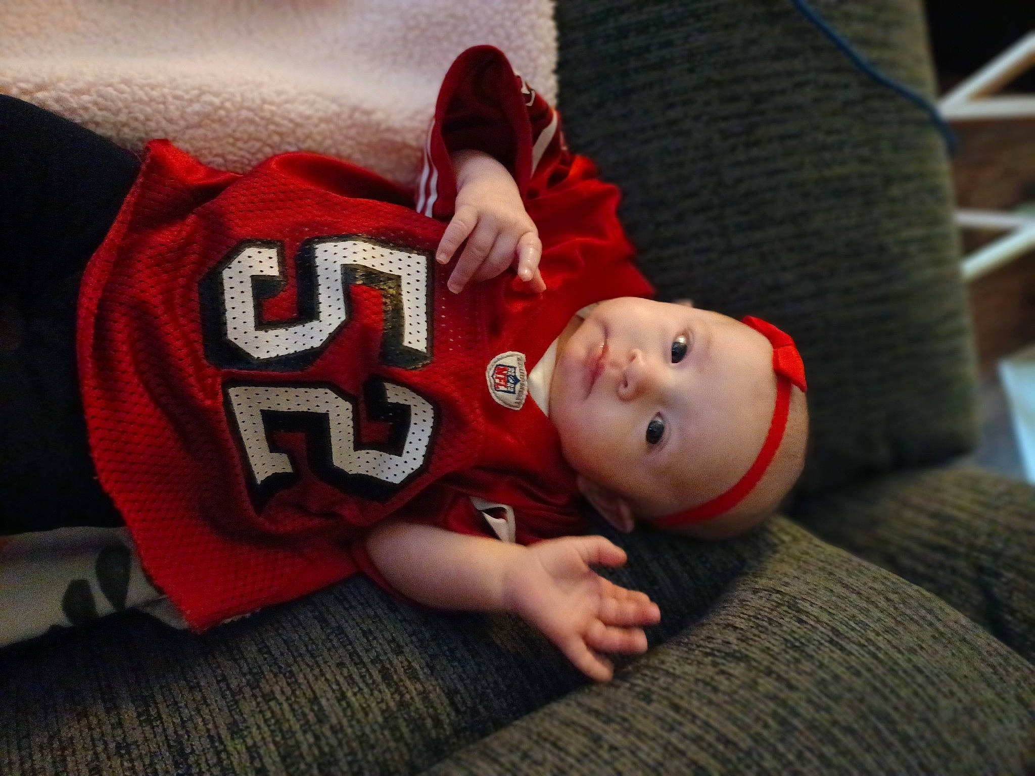 Millee joined the competition — help win amazing prizes! baby, baby_toddler_clothing, carmine, child, comfort, flash_photography, flooring, fun, hardwood, hat, headwear, human_body, knee, linens, person, room, sitting, sleeve, t_shirt, toddler