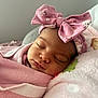 baby, sleeping, pink, blanket, headband, bow, floral, face, infant, child, soft, pillow, cute, peaceful, resting, closeup, indoors, person, newborn, wrapped