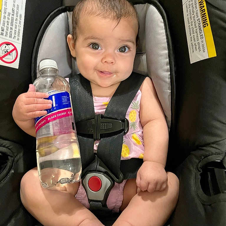Zoey joined the competition — help win amazing prizes! baby, babylaughing, bottle, car, clothing, cushion, face, happy, head, homedecor, lifejacket, person, photography, portrait, sitting, smile, transportation, vehicle, vest, waterbottle