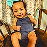 Olive joined the competition — help win amazing prizes! baby, child, smile, bow, onesie, chair, wooden_chair, blanket, knitted_blanket, happy, cute, infant, indoors, portrait, person, sitting, closeup, skin, headwear, toddler