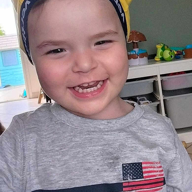 Soan a rejoint le concours — aidez-le/la à gagner de superbes lots ! american_flag, casual, child, cute, face, furniture, happy, headband, home, indoor, kid, person, playroom, portrait, shirt, smiling, storage, toddler, toys, yellow