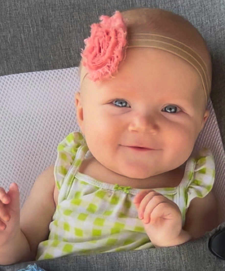 Kolbie joined the competition — help win amazing prizes! baby, child, smile, headband, flower, blue_eyes, green_dress, checkered_pattern, infant, cute, portrait, closeup, hand, skin, face, happy, sitting, indoors, texture, fabric