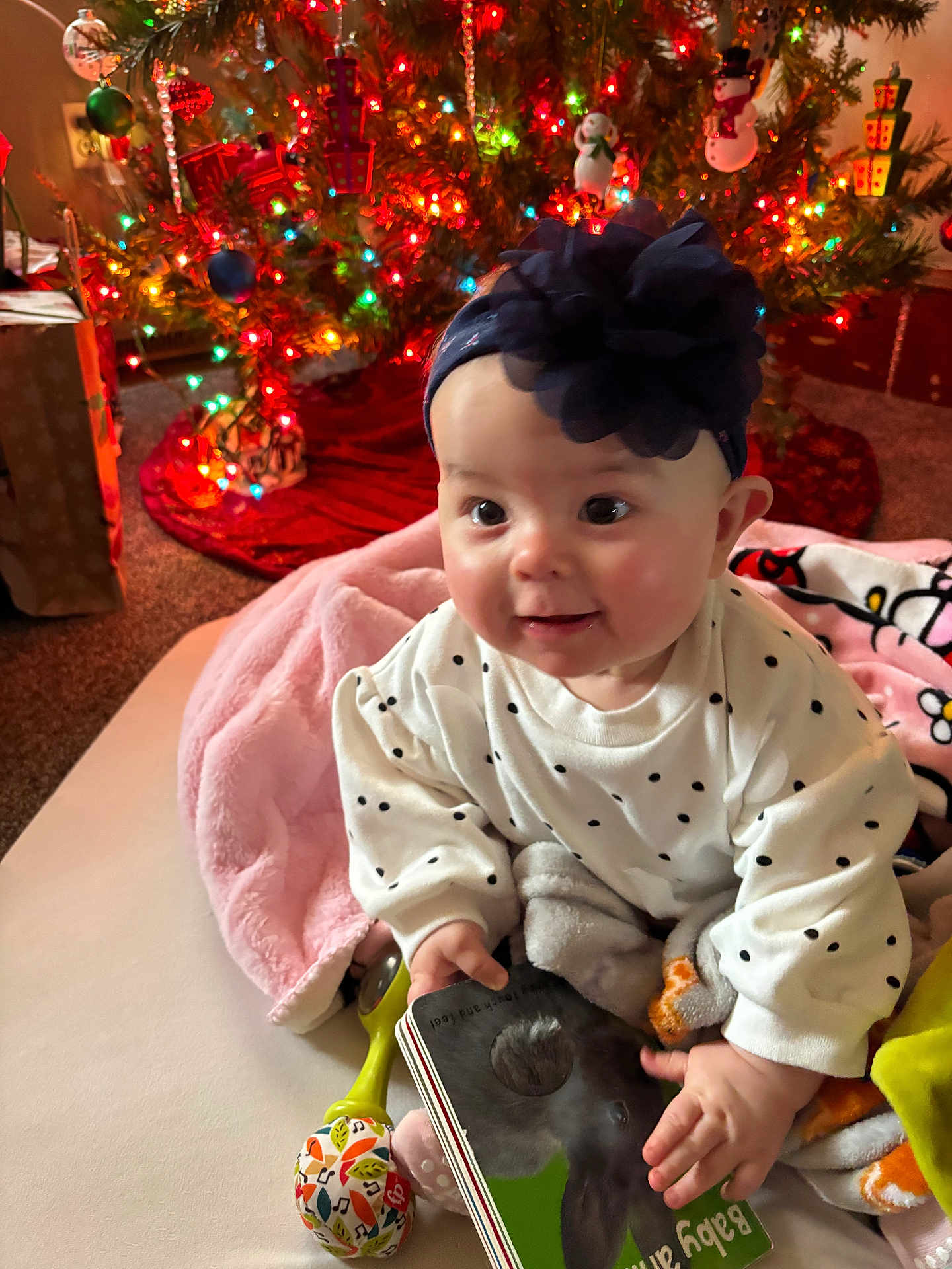 Saivanii joined the competition — help win amazing prizes! baby, infant, polka_dot, headband, flower, blanket, book, toy, christmas_tree, holiday, lights, decorations, carpet, smiling, indoors, child, cute, festive, happy, seasonal