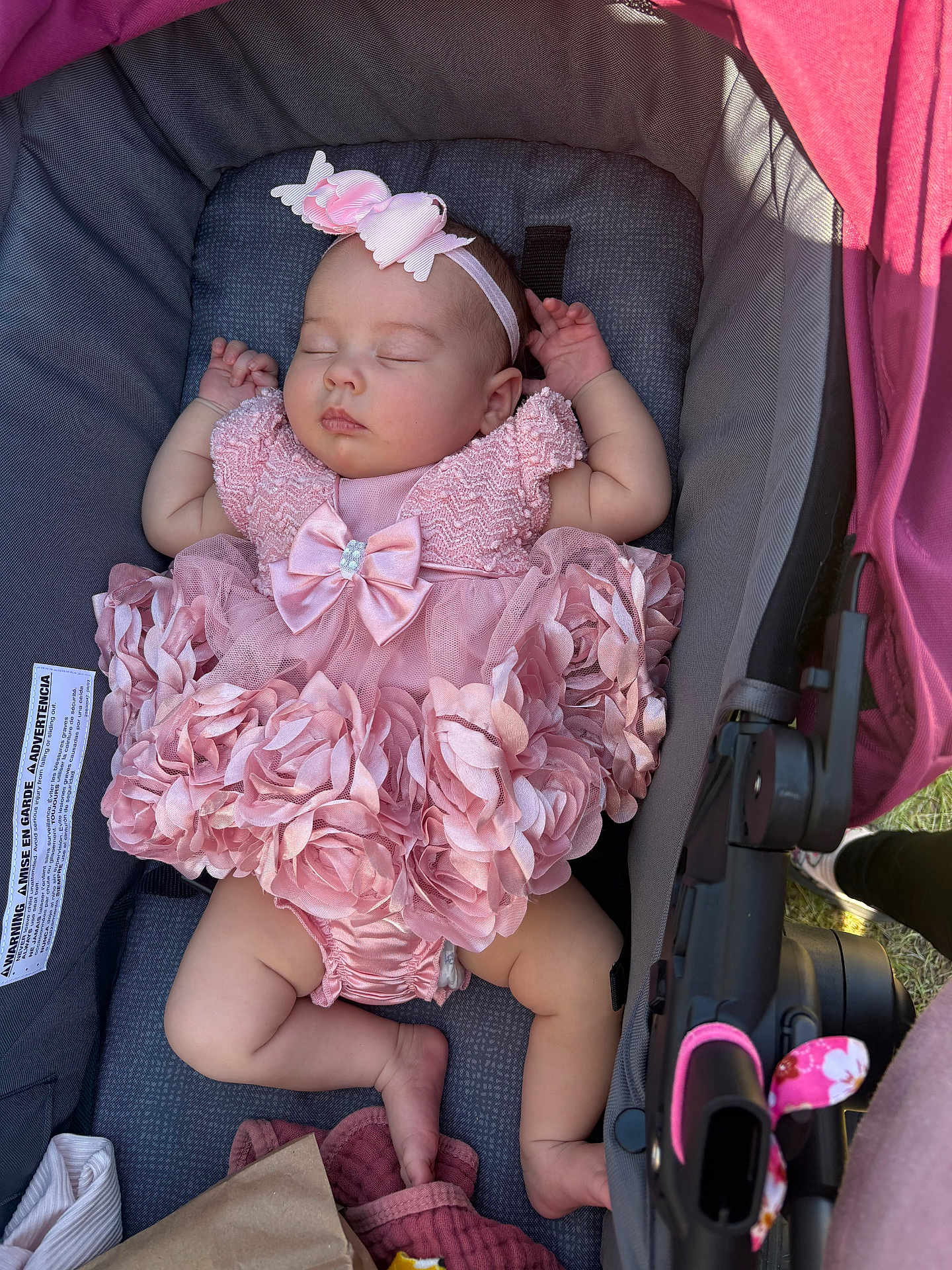 Kayleigh is registered to the contest to win money with this photo: baby, infant, sleeping, stroller, pink_dress, headband, bow, floral_ruffles, canopy, carseat, baby_legs, closed_eyes, peaceful, newborn, fabric, buckle, seat_pad, accessory, sunlight, cute