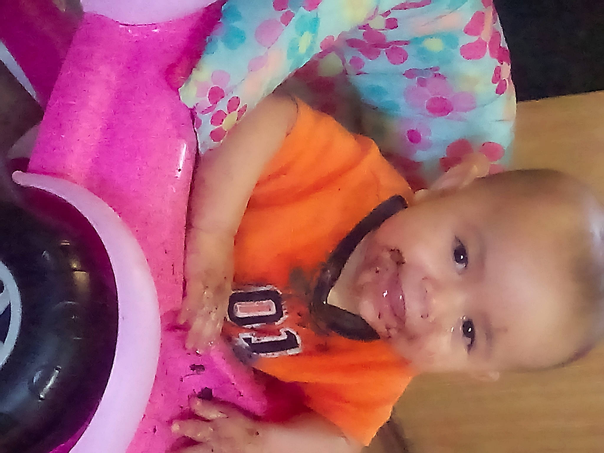 Grayson is registered to the contest to win money with this photo: automotive_tire, baby, baby_playing_with_toys, baby_toddler_clothing, cheek, child, finger, fun, happy, magenta, mouth, person, pink, product, purple, skin, smile, textile, toddler, violet