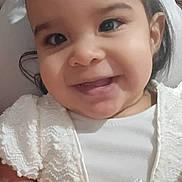 Lorraine is registered to the contest to win money with this photo: baby, child, toddler, girl, smiling, happy, portrait, close_up, face, eyes, hair_bows, white_dress, formal_clothing, lace, indoor, sitting, hands, infant, adorable, photography
