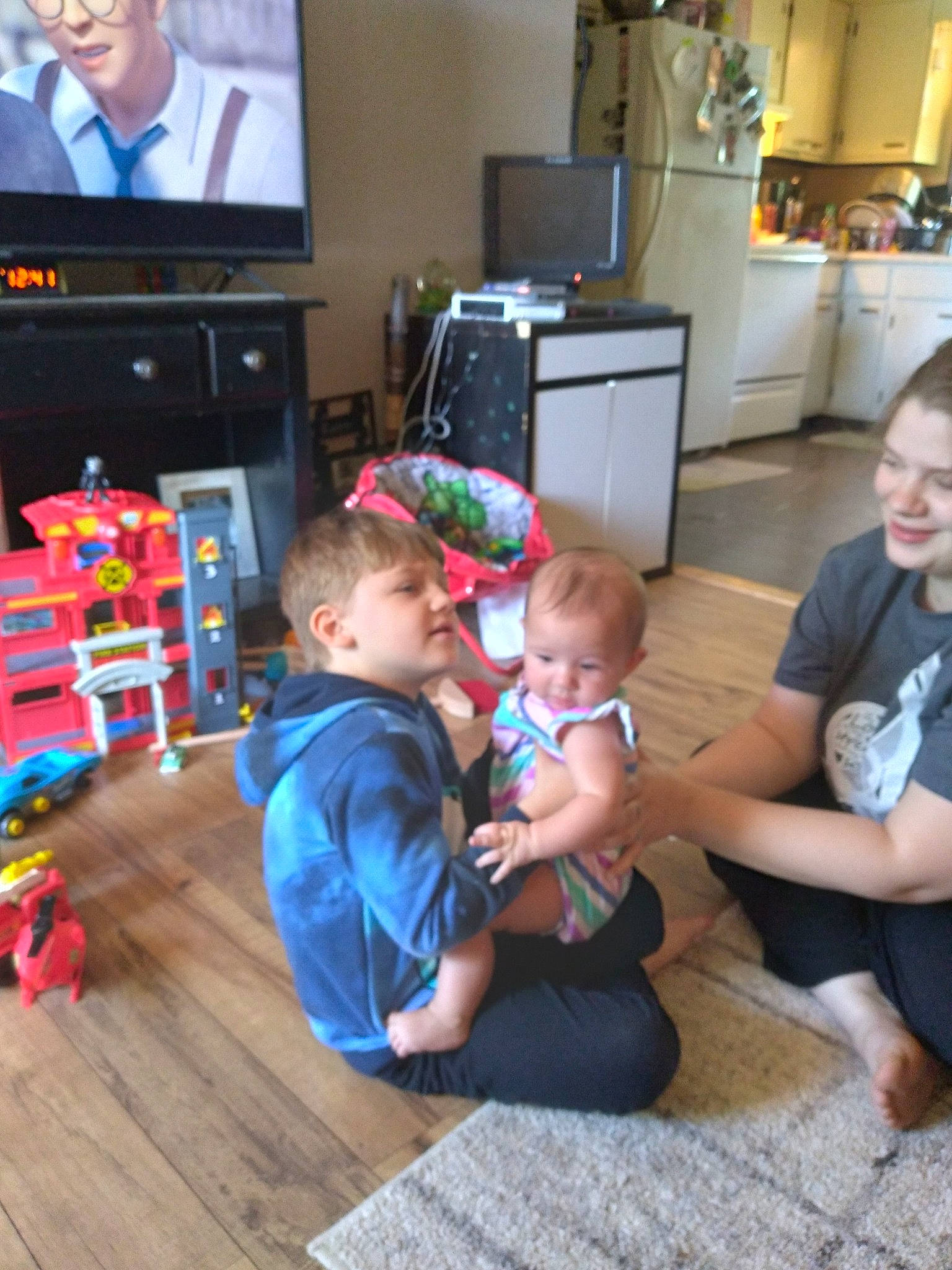 Sammie joined the competition — help win amazing prizes! baby, cabinetry, child, entertainment_center, event, floor, flooring, fun, hardwood, home_appliance, joy, kitchen_appliance, leisure, living_room, person, shorts, standing, t_shirt, television, television_set