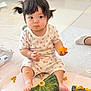 toddler, child, baby, pumpkin, food, messy, sitting, pigtails, indoors, floor, curious, cute, playful, hands, feet, orange, seeds, clothing, white, expression