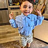 Leonardo joined the competition — help win amazing prizes! child, boy, smiling, indoor, shirt, shorts, standing, kitchen, banana, water_container, high_chair, carpet, furniture, curtain, cabinet, refrigerator, happy, pose, person, casual_clothing
