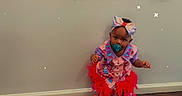 Emani joined the competition — help win amazing prizes! toddler, child, pacifier, bow, colorful_clothing, frilly_dress, wooden_floor, birthday_poster, baby, smiling, number_one, wall, indoor, celebration, stars, headwear, footwear, standing, cute, party