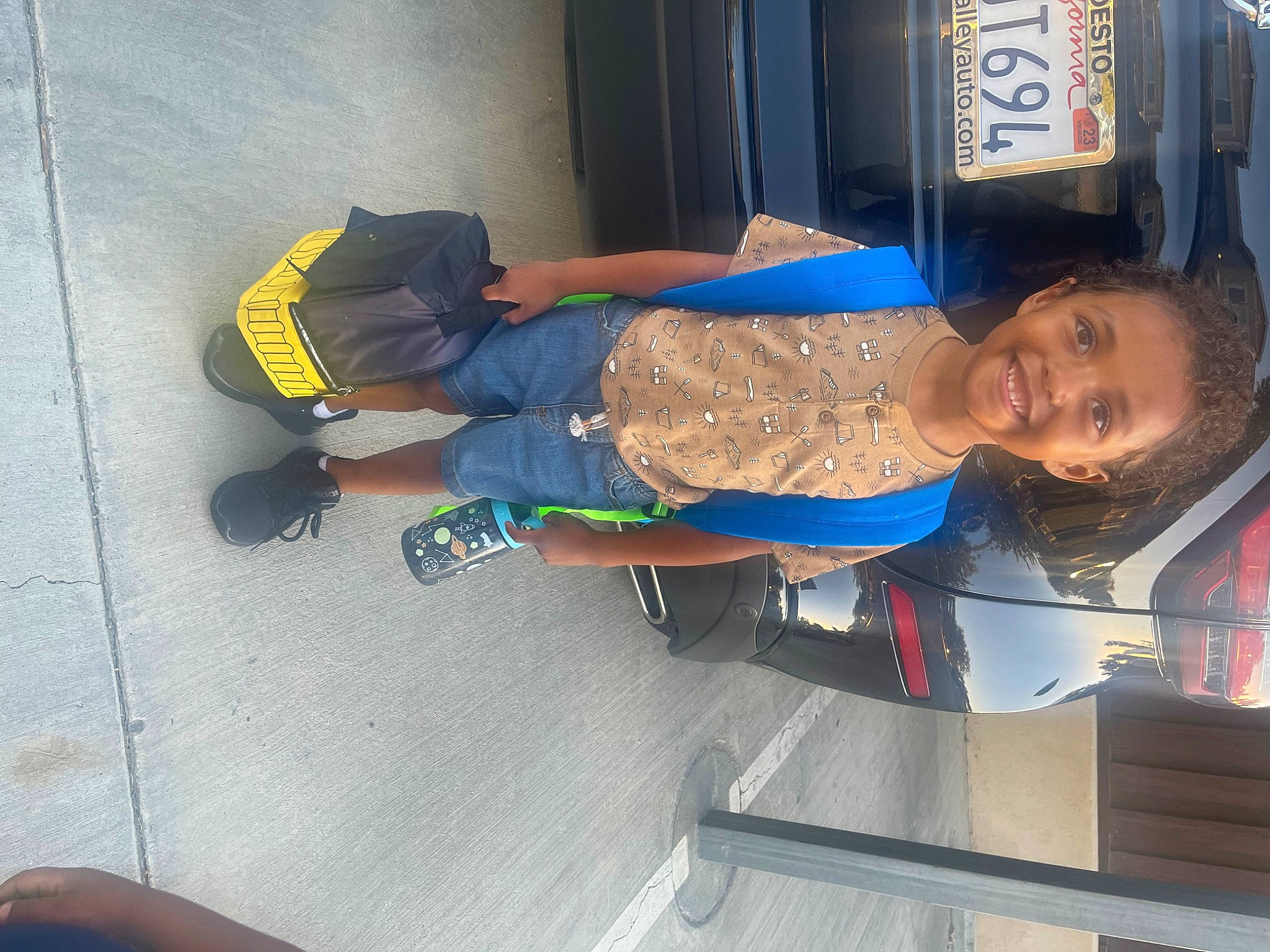 Isaiah is registered to the contest to win money with this photo: child, comfort, elbow, electric_blue, flooring, fun, human_leg, joy, knee, lap, leg, machine, person, shorts, sitting, smile, t_shirt, thigh, toddler, transport