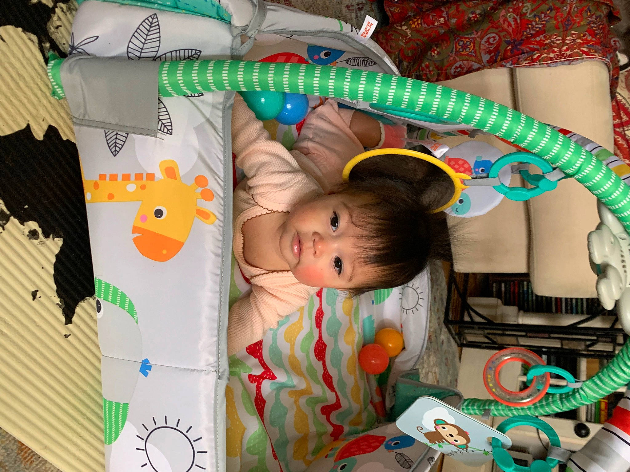 Ezra is registered to the contest to win money with this photo: art, baby, baby_products, baby_toys, bed, bedtime, child, green, happy, infant_bed, linens, pattern, person, play, room, smile, stuffed_toy, textile, toddler, toy