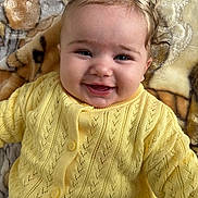 Arya a rejoint le concours — aidez-le/la à gagner de superbes lots ! baby, infant, smiling, yellow_sweater, bow, hair, blanket, closeup, portrait, blue_eyes, rosy_cheeks, buttoned_cardigan, knitted, lying_down, cozy, adorable, child, face, eyelashes, happy