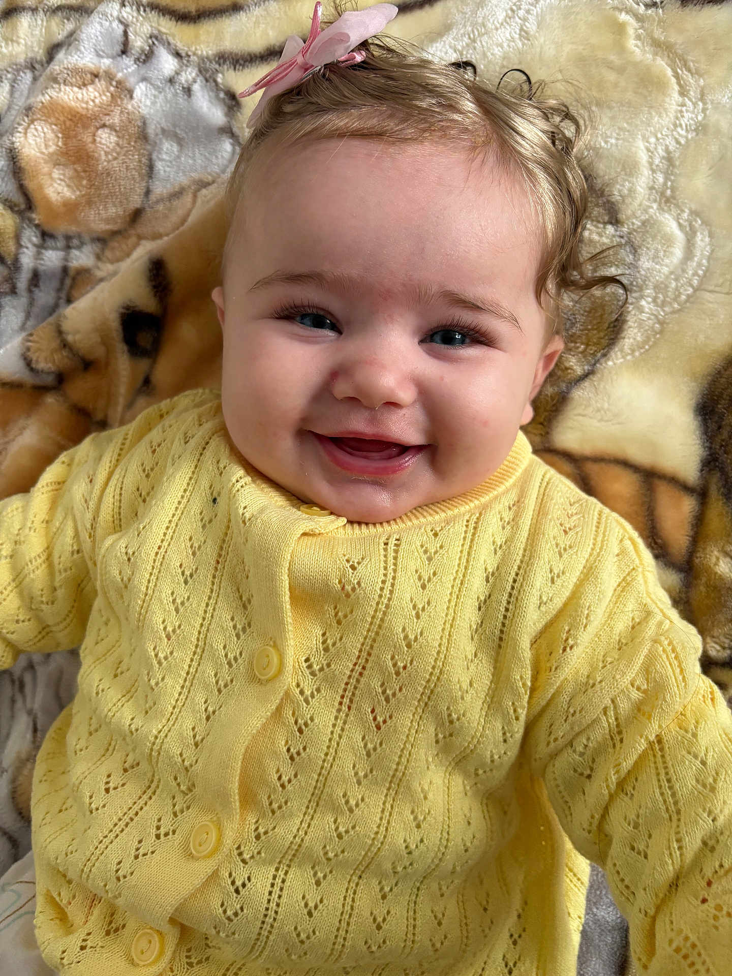 Arya a rejoint le concours — aidez-le/la à gagner de superbes lots ! baby, infant, smiling, yellow_sweater, bow, hair, blanket, closeup, portrait, blue_eyes, rosy_cheeks, buttoned_cardigan, knitted, lying_down, cozy, adorable, child, face, eyelashes, happy